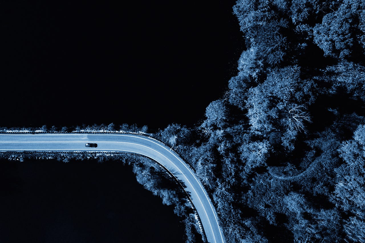 Road in the autumn forest aerial view with lake